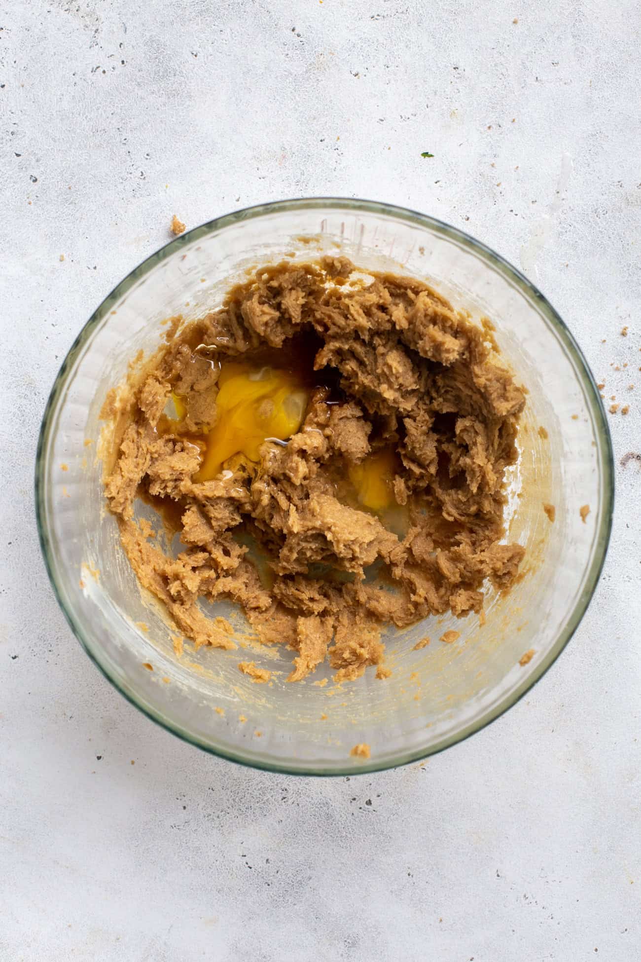 overhead view of eggs mixing into creamed butter and sugar.