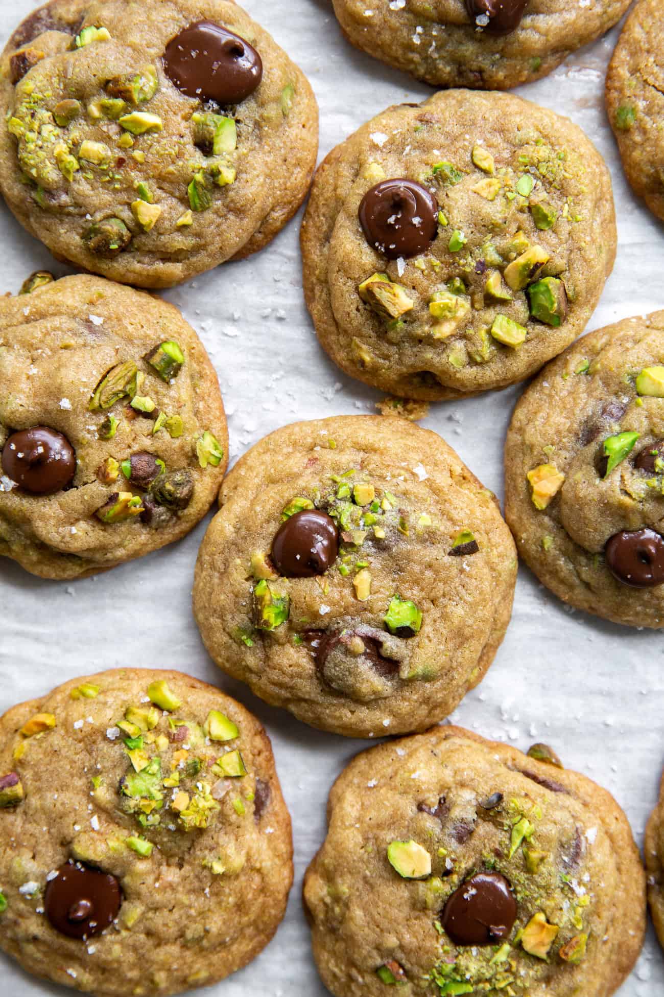 overhead view of pistachio chocolate chip cookies on parchment paper.
