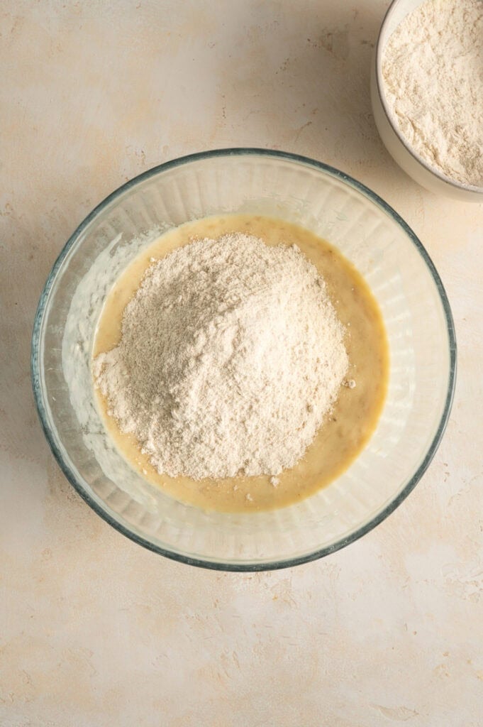 dry ingredients mixing in bowl of wet ingredients.