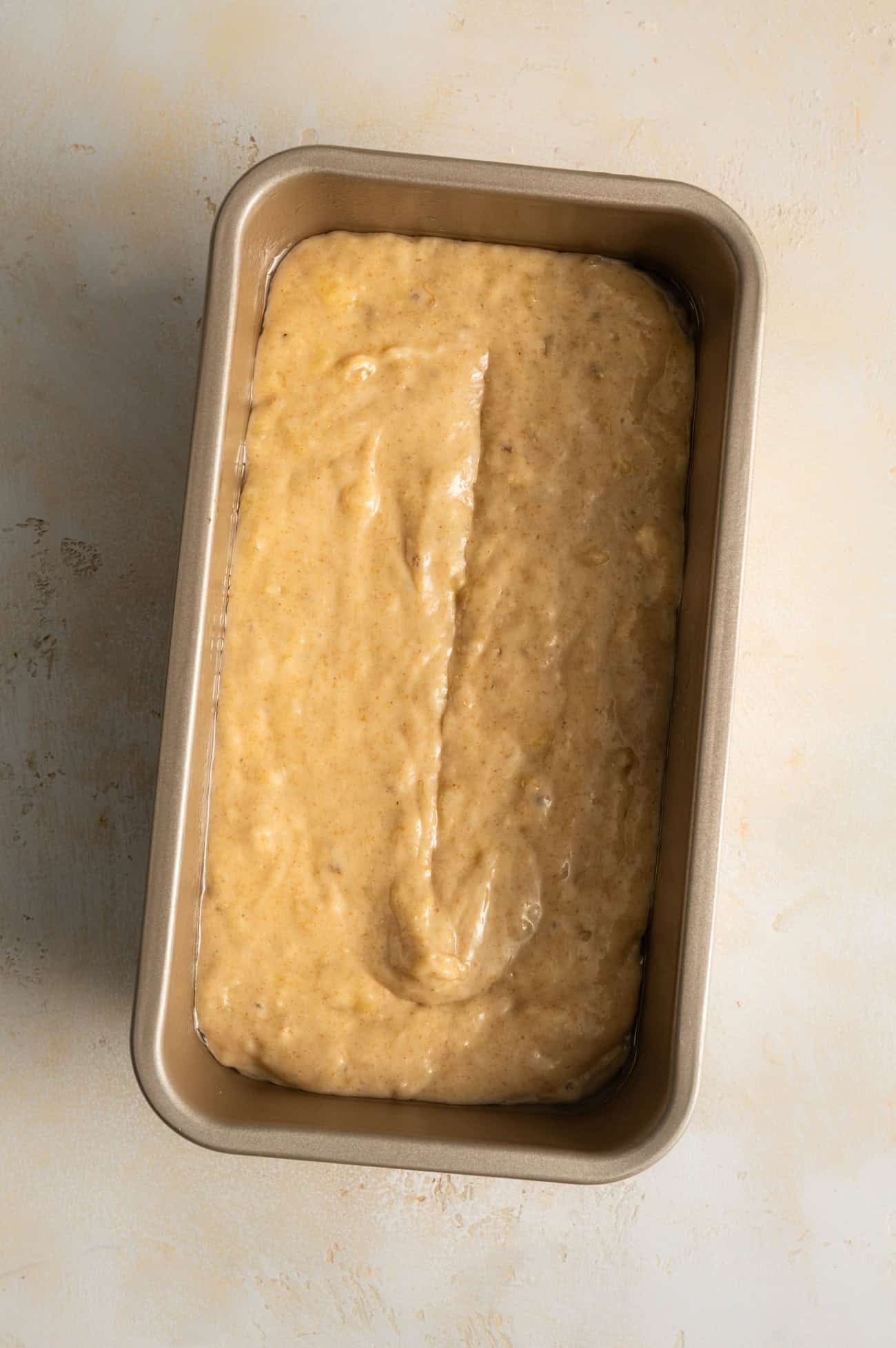 overhead view of banana bread batter in loaf pan.