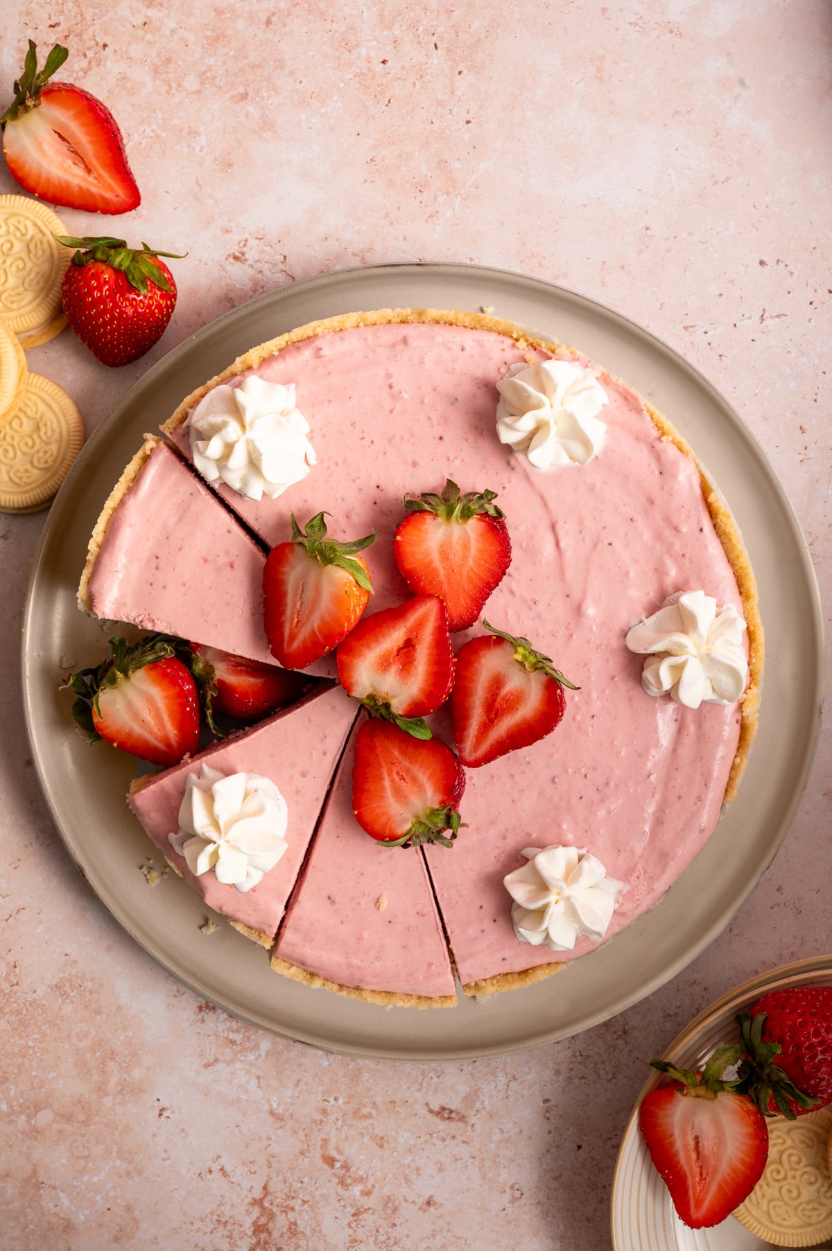 overhead view of no bake strawberry cheesecake on plate with fresh strawberries and whipped cream.