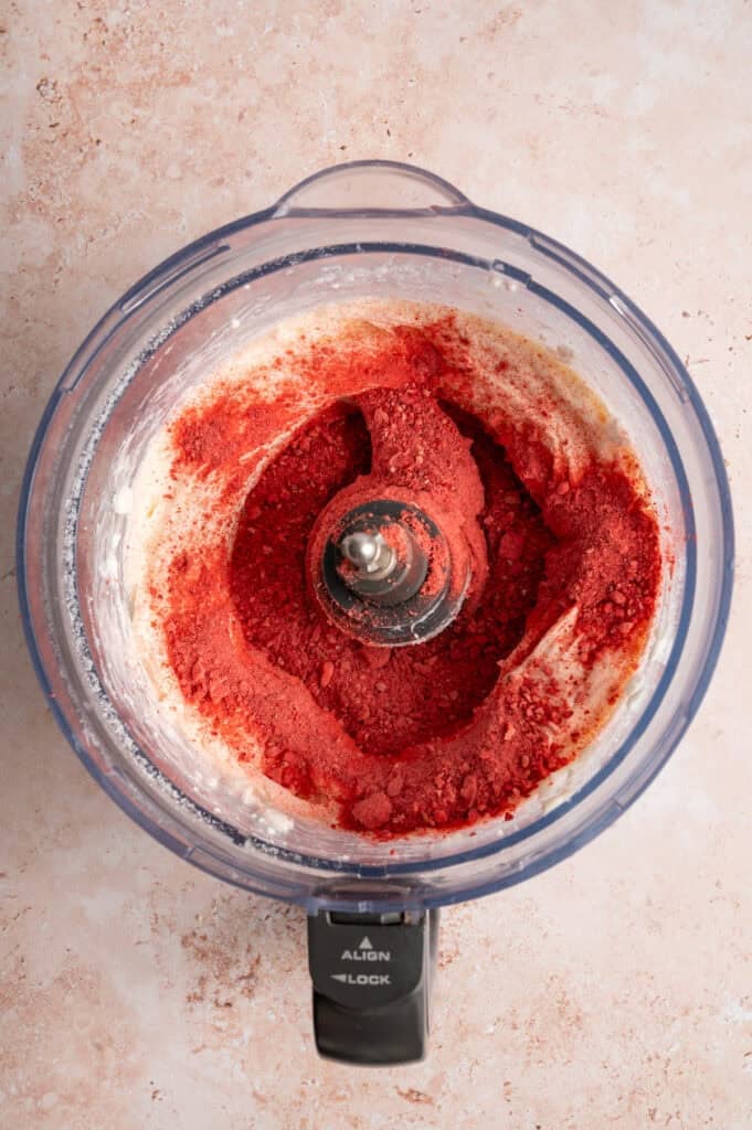 bowl of freeze dried strawberries in blended cream cheese and food processor bowl.