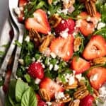 overhead view of strawberry arugula salad with feta and pecans.