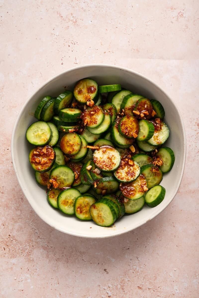 overhead view of spicy asian sauce over cucumbers.