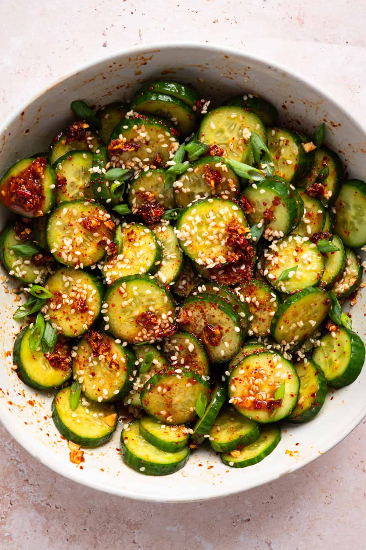 asian cucumber salad in white bowl.