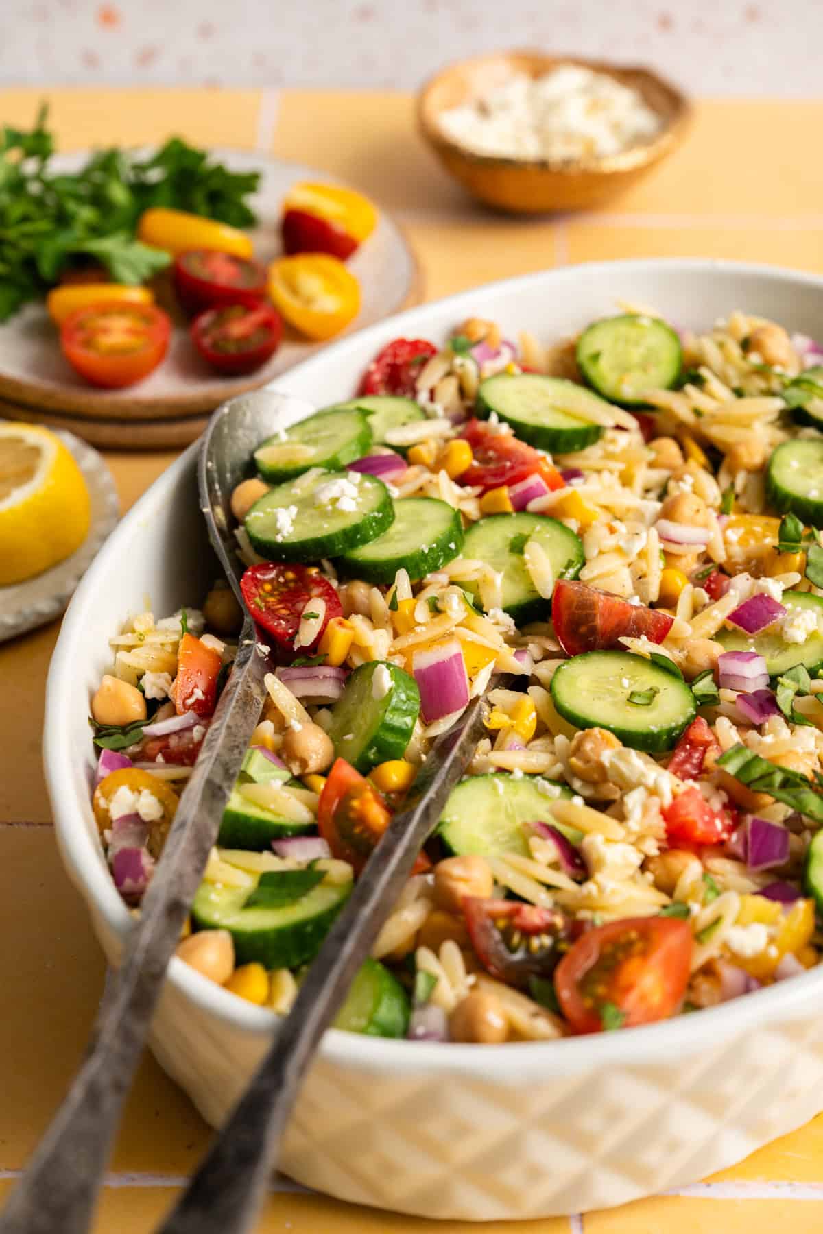 salad serves in oval dish of summer orzo salad with cucumbers.