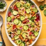 overhead view of summer orzo pasta salad with fresh cucumbers, feta and tomatoes.