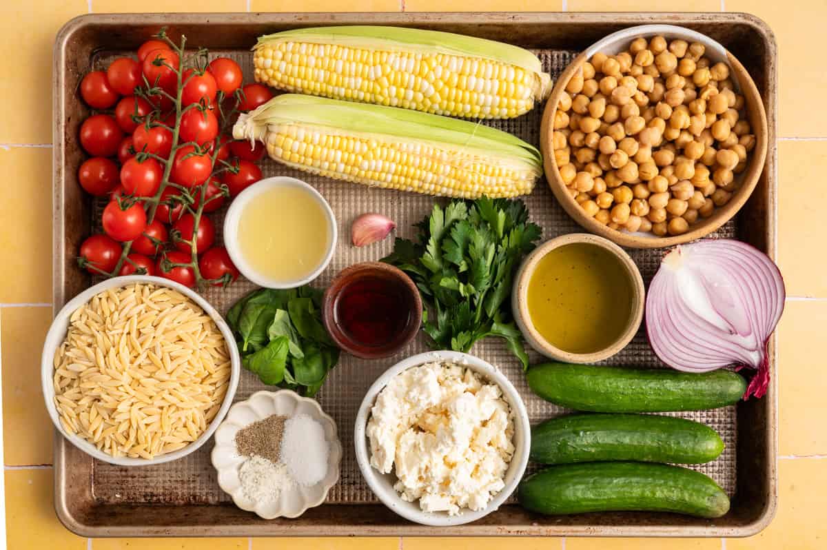 vegetables, herbs and ingredients for an orzo salad recipe.