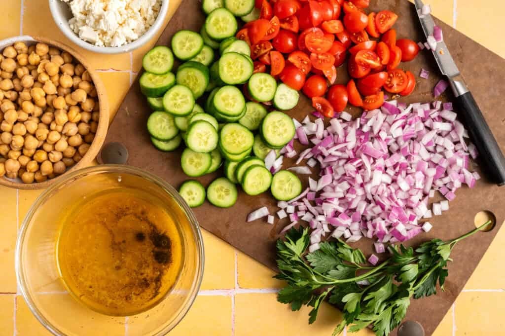chopped vegetabels on cutting board on yellow background.