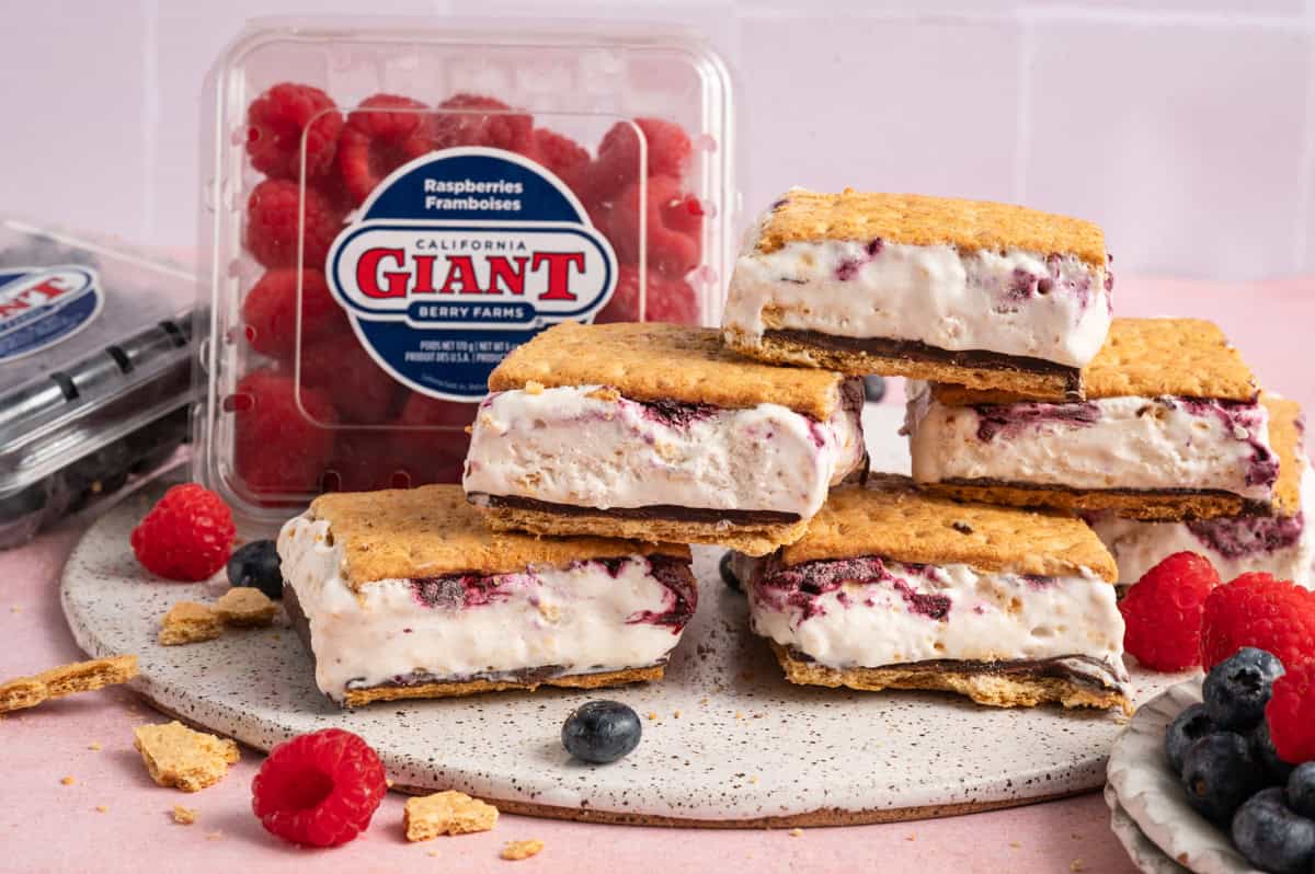 frozen smores bars stacked with berries in background.