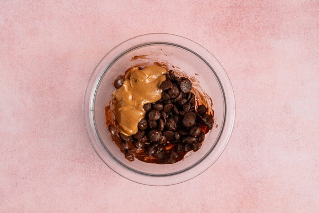 chocolate chips partially melted in glass bowl with peanut butter.