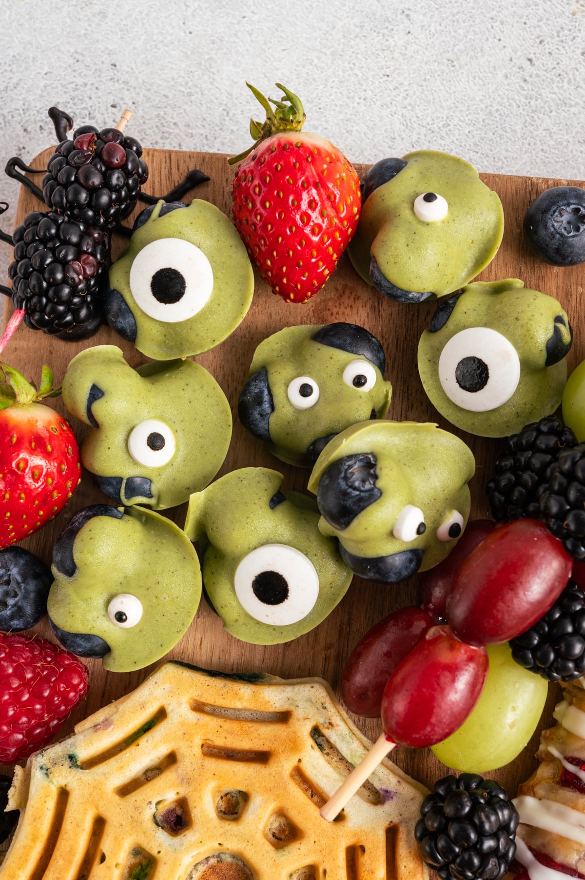 green chocolate covered blueberries with candy eyes.